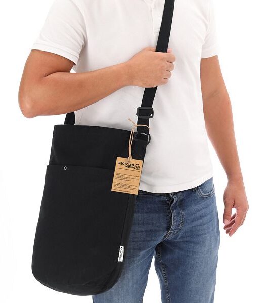 Borsa in cotone riciclato da 270g/m2. Forma cilindrica originale con grande capacità, con scomparto principale, tasca interna ausiliaria e pratica tasca esterna con chiusura a clip in metallo. Elegante colore nero, finitura cucita e tracolla lunga regolabile e rinforzata. Logo Cotone Riciclato sull'etichetta esterna.